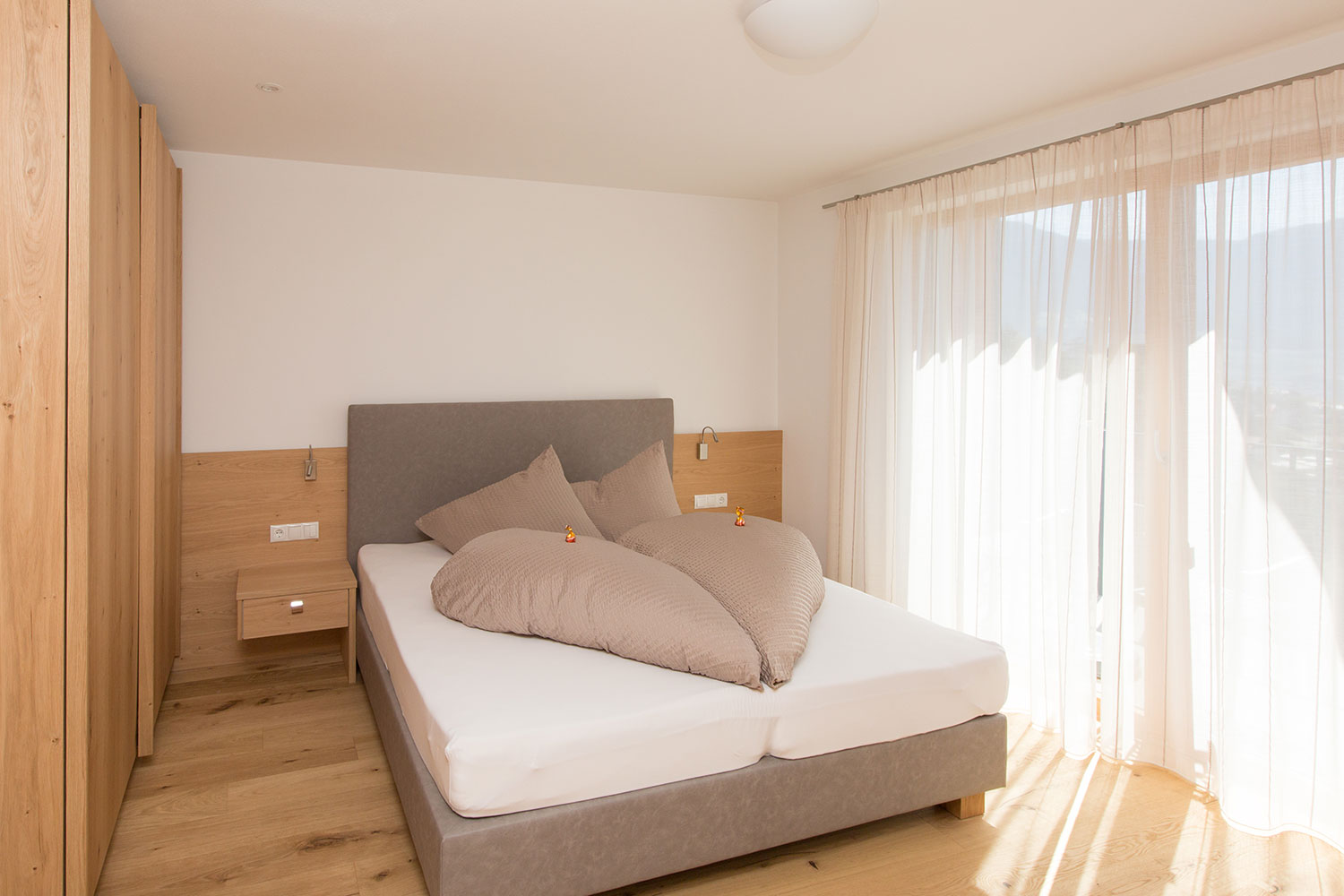 Apartment St. Peter – Schlafzimmer mit Doppelbett und Balkon